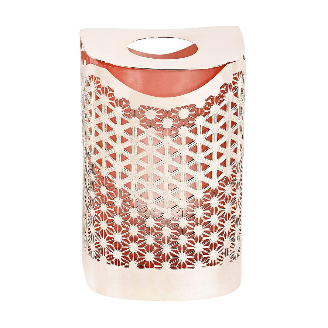 Zen Oil Burner is a rectangular silver oil burner covered in a dense floral lattice, letting light filter through a coral-toned glass liner - white background
