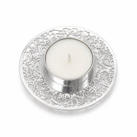 Tree Of Life Round Tealight Small is a silver tealight holder shaped as a small saucer, its rim pierced with a fine scrolling tree pattern around a flat central seat - white background