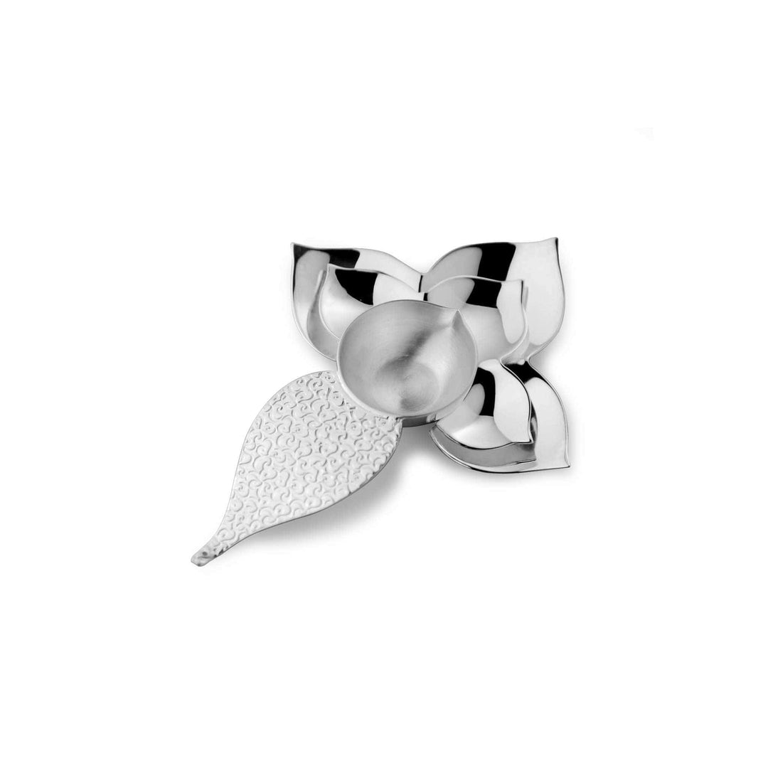 Diya Kamal shapes a silver diya like a blooming kamal, one petal carrying a fine scroll texture against three plain polished petals - white background