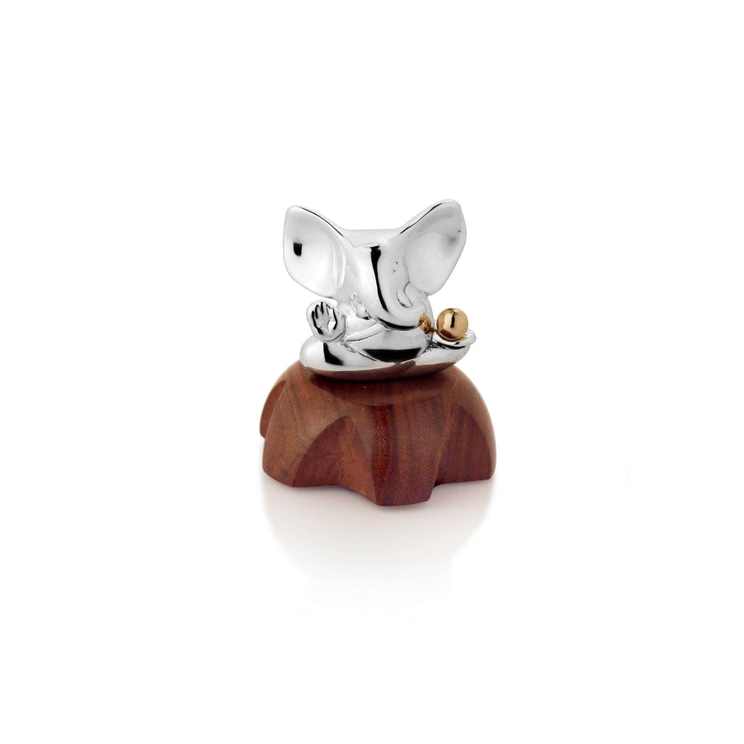 Ganesh Lamba Karma sits with one hand raised in blessing and the other resting beside a small gold-toned bead