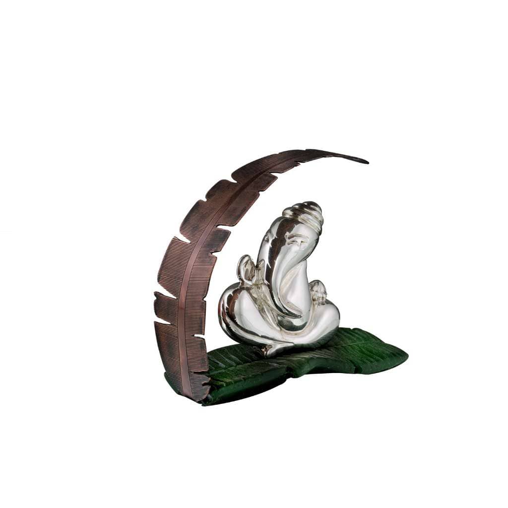 Ganesh Banana Leaf sets a smooth, stylized sterling silver Ganesha bust against a large green banana leaf base - white background