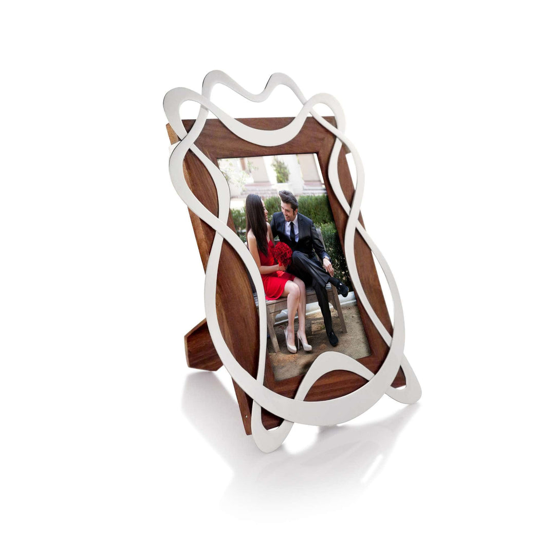 Photo Frame Confetti is a silver frame that loops ribbon-like wirework over a dark wood backing, giving it an open – Small