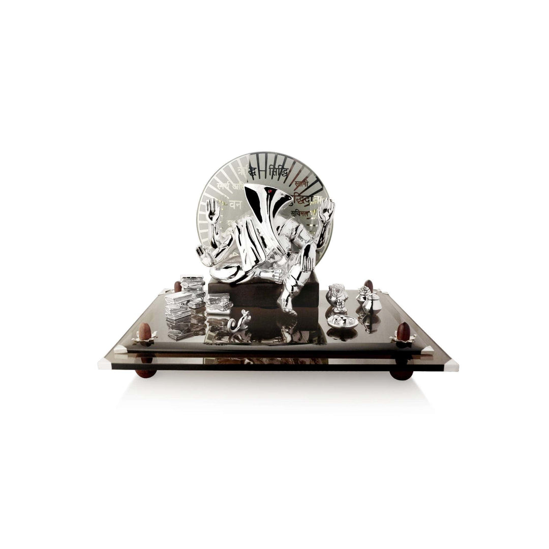 Ganesh Riddhi Siddhi is a four-armed sterling silver Ganesha idol seated against an etched glass halo inscribed with the Riddhi Siddhi mantra – Medium