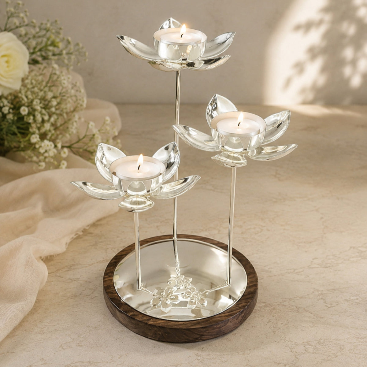 Lotus Centerpiece, a silver tealight holder with three lit lotus blooms
