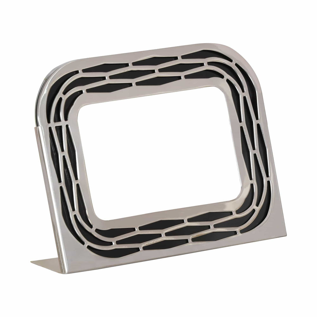 Chakra Photoframe is a silver photoframe that gets real visual depth from a radiating hexagonal cutwork pattern set against a black backing on its rounded rectangular border - white background
