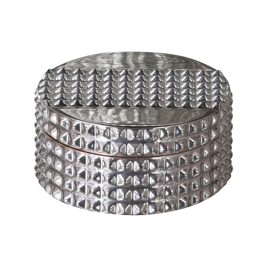 Supari Box with Spoon pairs a round silver box, its all-over pyramid-textured surface finished with a lift-off lid - white background