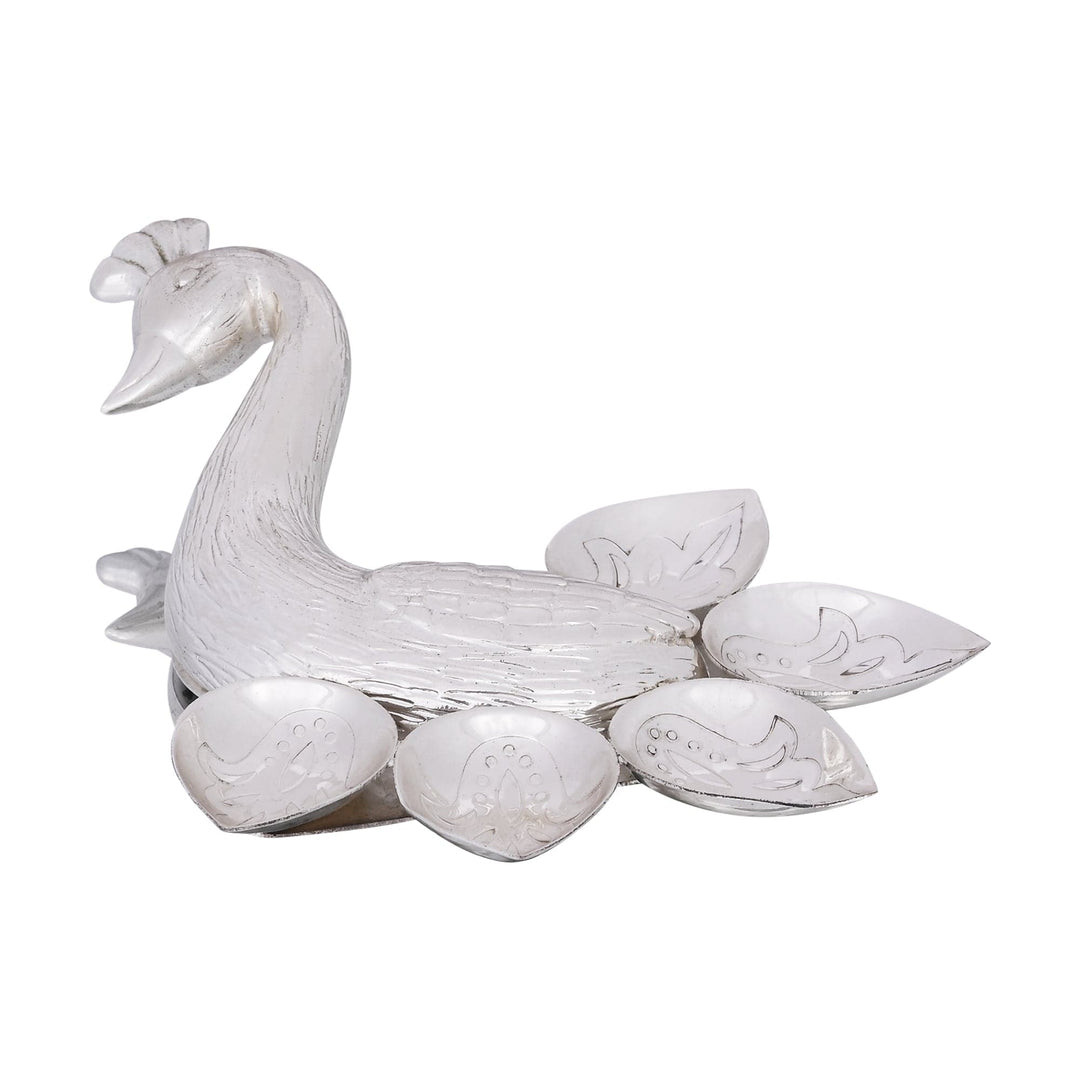 Silver Plated Diya Mayur shapes a silver diya like a peacock, its curved neck and crested head carrying fine feather-texture engraving - white background