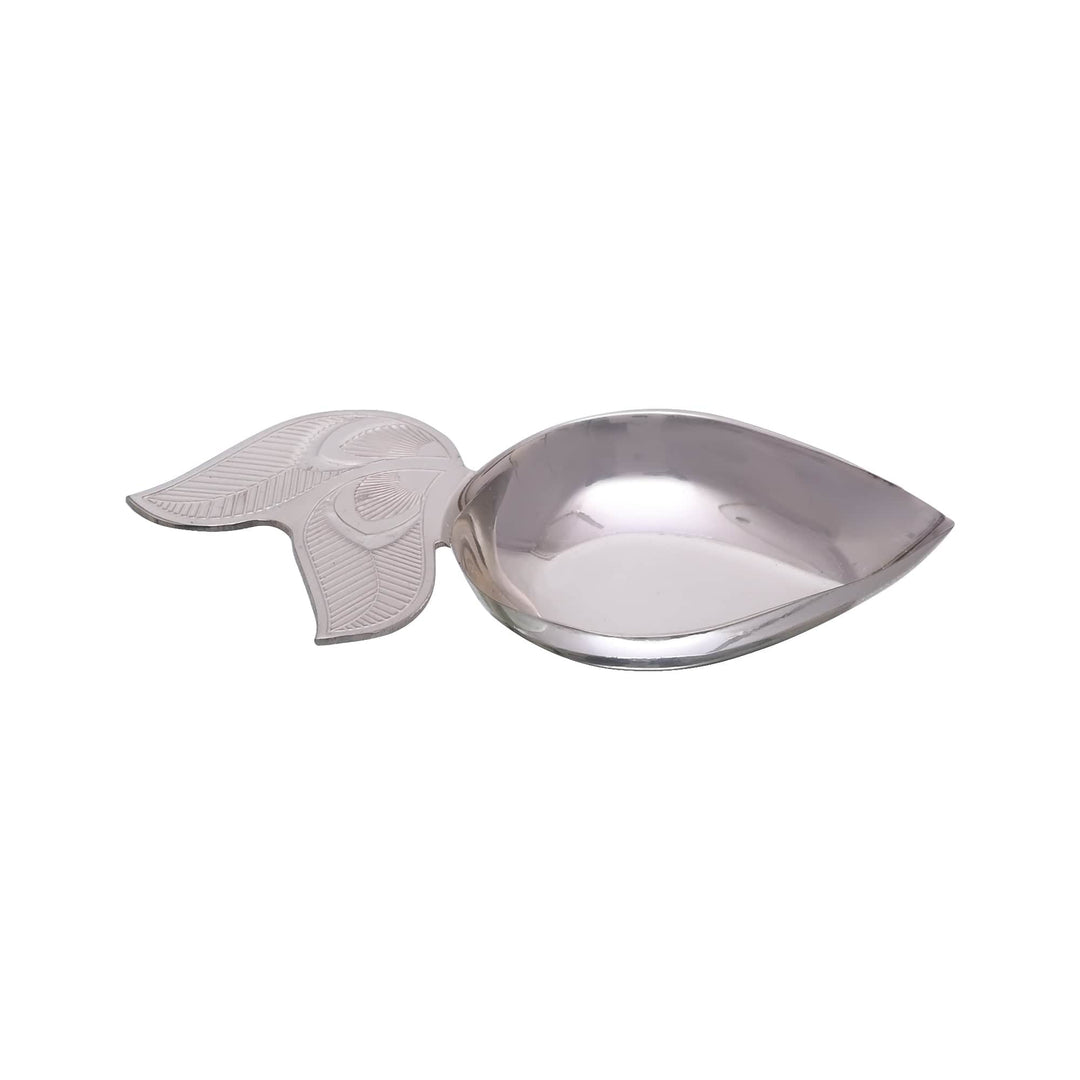 Pihoo Diya keeps a silver diya simple, a single leaf-shaped bowl with a small fern-leaf handle, sitting flat and steady on any surface - white background
