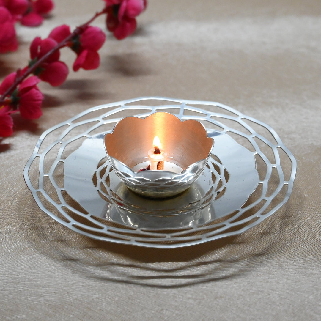 Chakra Jyot is a silver diya that sets a single scalloped wick cup at the centre of a radiating wirework tray – Large
