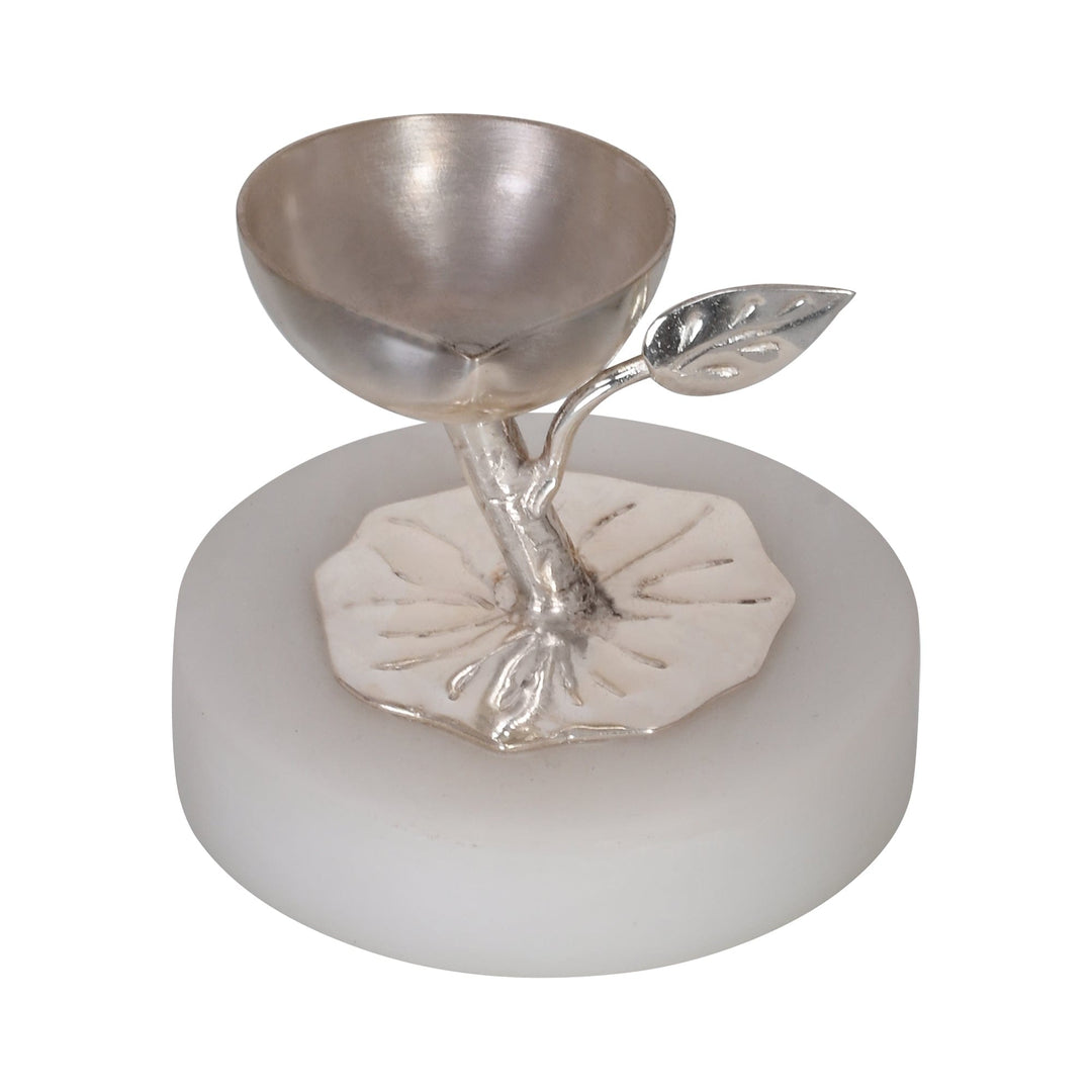 Branch Diya is a silver diya that sets a single wick cup on a slender branch, with one leaf unfurling beside it - white background