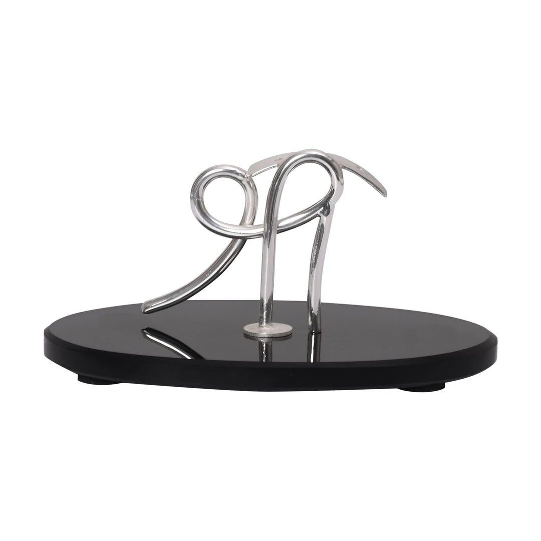 Shree Incense Holder is a silver incense holder shaped as a wire sculpture that curves and loops into an abstract, calligraphic silhouette - white background
