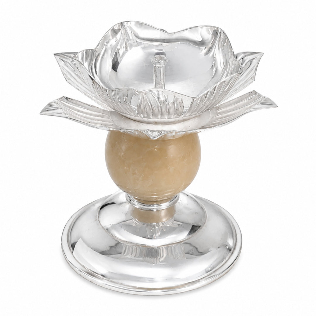 Kamal Jyot is a silver diya shaped as a chased lotus raised on a cream stone ball stem over a stepped silver foot - white background