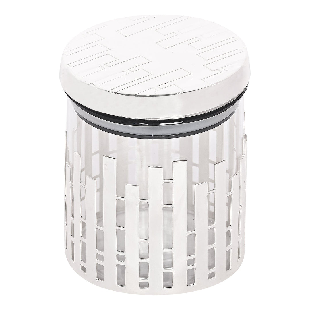 Jar Round Lamela wraps a graphic vertical-bar cutout pattern around the clear glass body of a silver jar, set beneath a matching pierced lid - white background