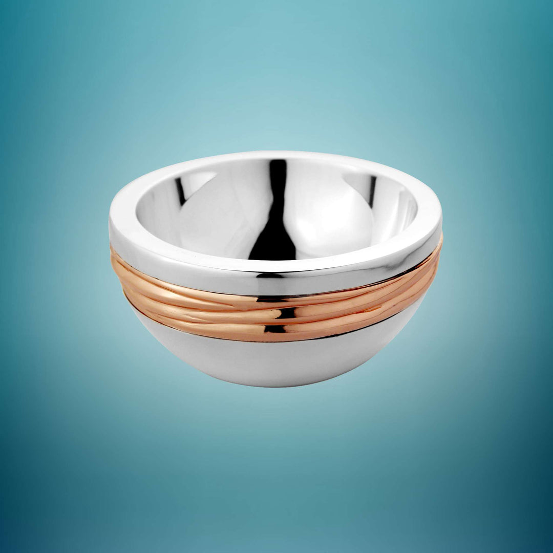 Bowl Wedge circles a ribbed rose-gold band around the middle of this silver bowl, its rounded lower body carrying a warm accent line – Large