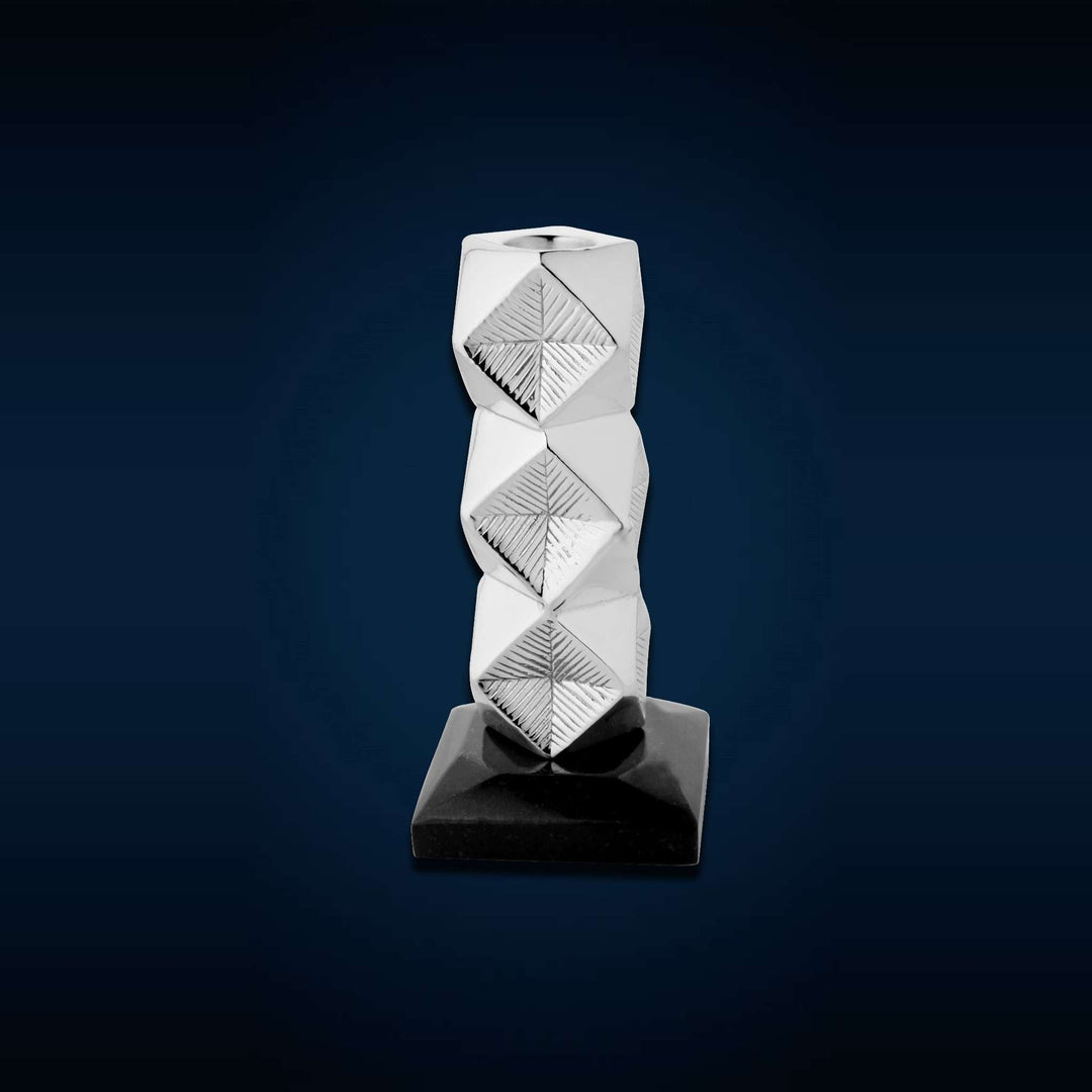 Candle Stand Proton is a sterling silver candle stand with a bold geometric silhouette, its faceted column built from stacked – Large