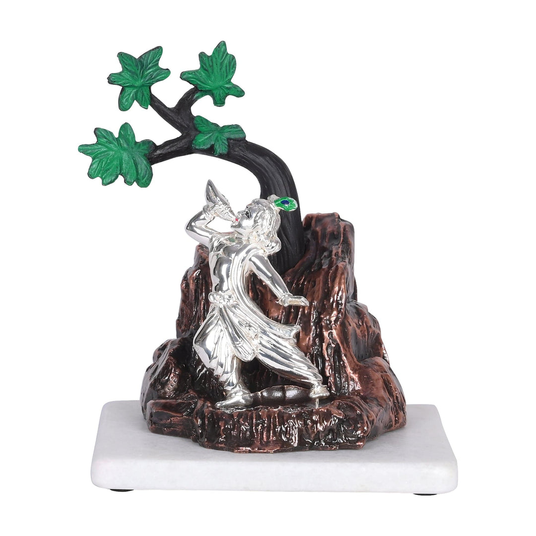 Shank Naad Krishna is a sterling silver idol of Krishna standing atop a rugged copper-toned rock - white background