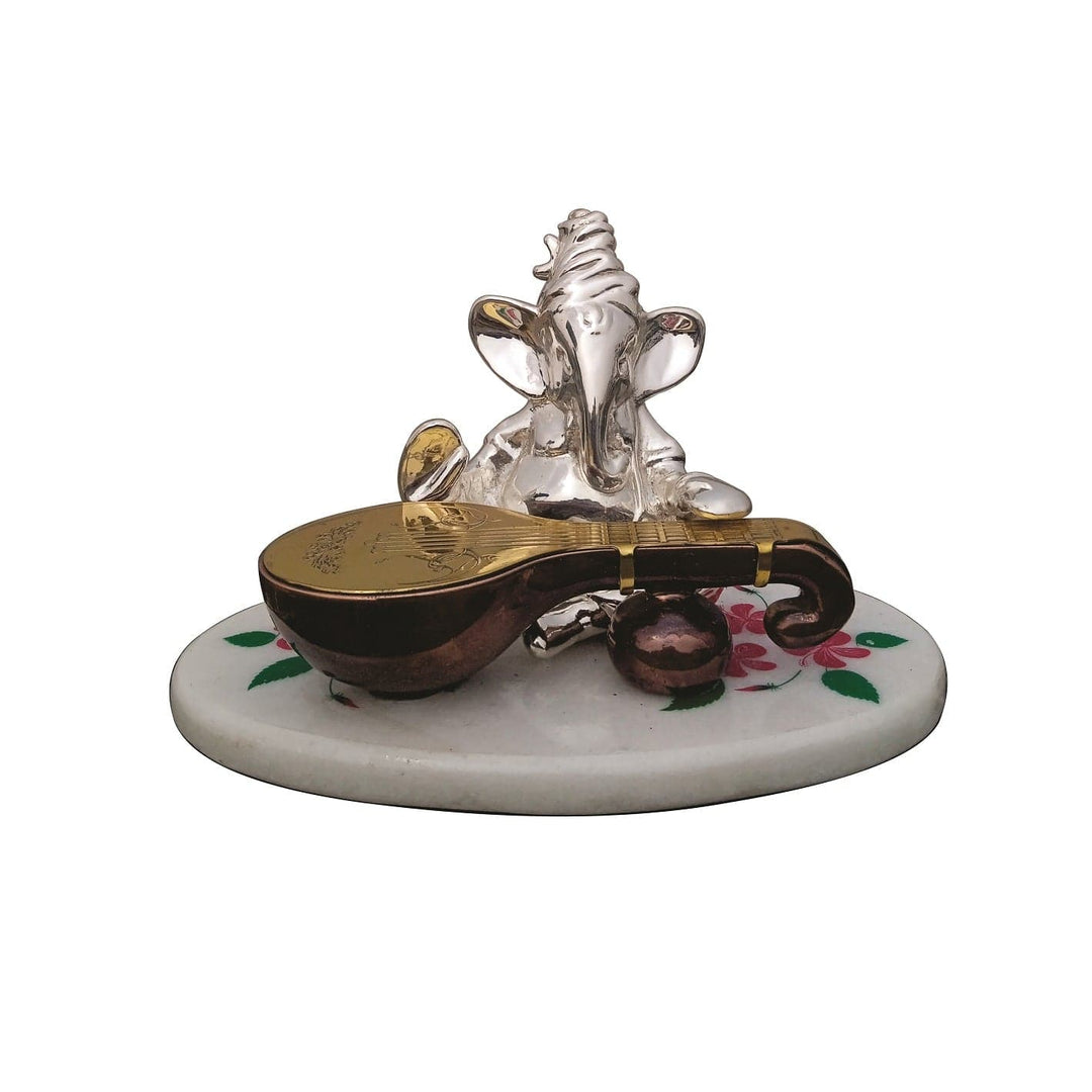 Veena Ganesh depicts a sterling silver Ganesha idol seated and playing a veena rendered in warm bronze and gold tones - white background