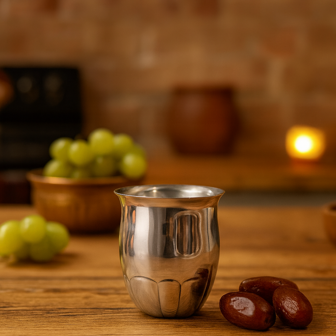 Aster Tumbler carries a small geometric motif embossed above the fluted, lotus-petal base of this silver - lifestyle mood shot - white background