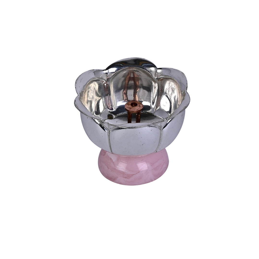 Divine Bloom Diya is a silver diya that rests a single scalloped lotus cup on a rounded pink stone-coloured base - white background