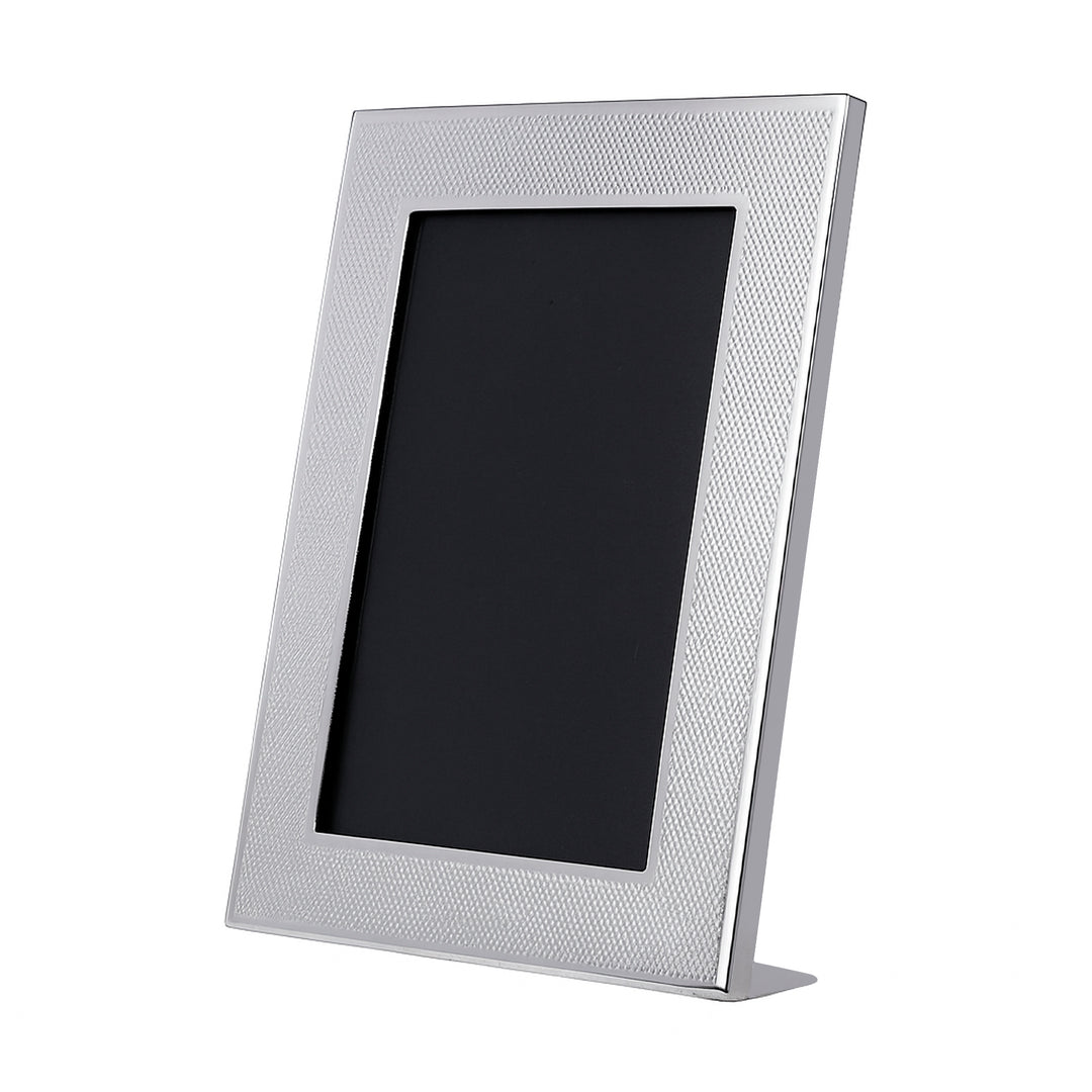 Photoframe Nouveau is a silver photo frame covering its face in a fine crosshatch texture that catches the light like woven fabric – Small