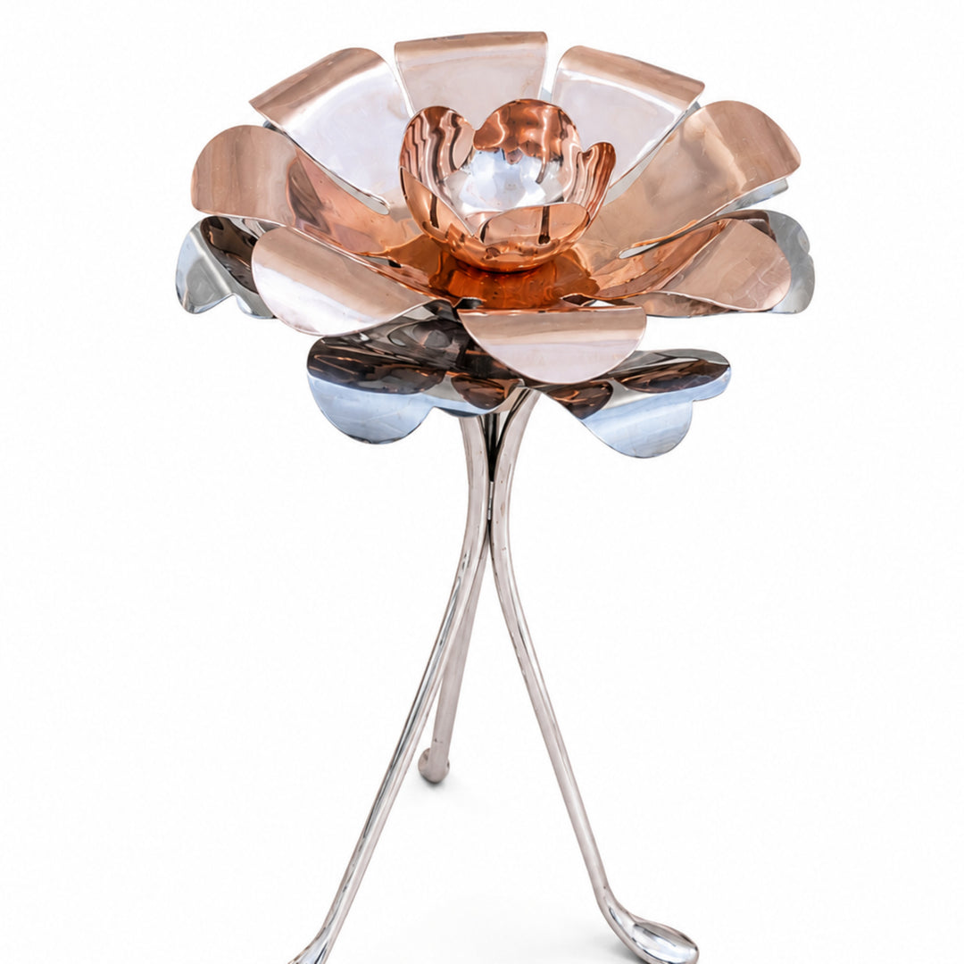 Kusum Diya Small is a silver diya shaped as an open flower, with rose-gold and mirror-silver petal tiers standing on three splayed legs - white background