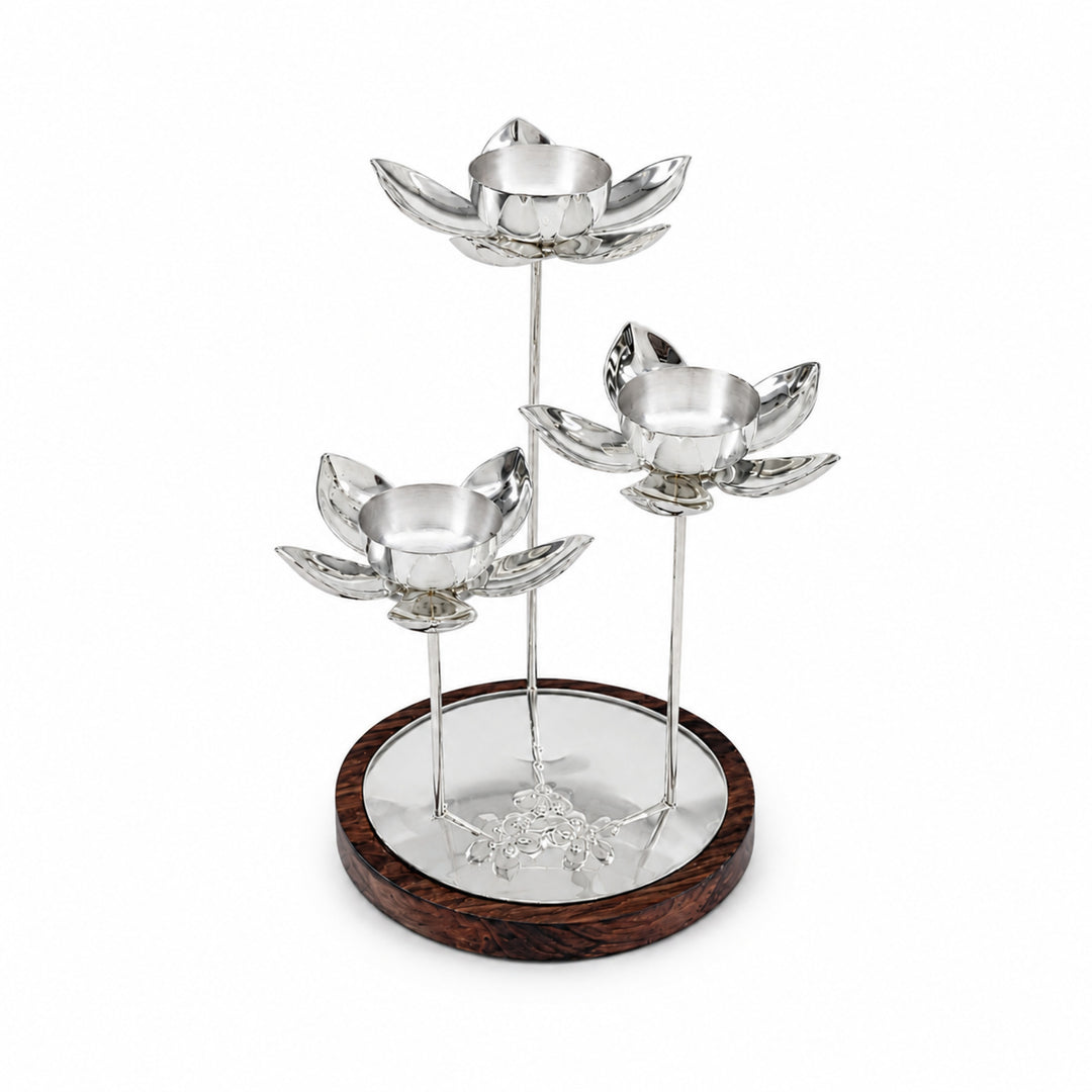 Lotus Centerpiece is a silver tealight holder with three petalled lotus blooms on slim stems above a wood-rimmed mirrored tray - white background