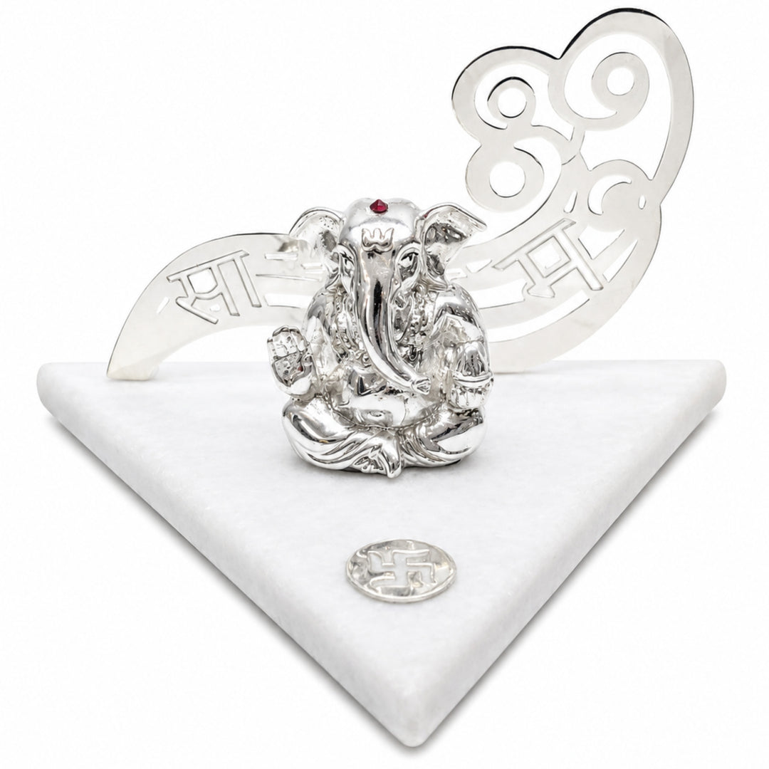 Sargam Ganesha is a silver ganesh idol on a triangular white marble slab, with a pierced silver panel of musical notation rising behind the figure - white background