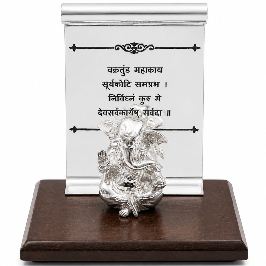 Scroll Ganesha is a silver ganesh idol set in front of an engraved scroll plaque on a dark wood plinth - white background