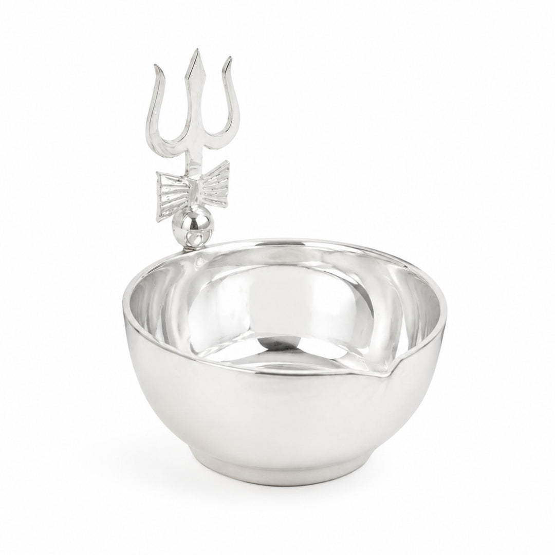 Trishul Diya is a silver diya with a plain mirrored bowl and a flat cut trishul crossed by a damaru above the rim - white background