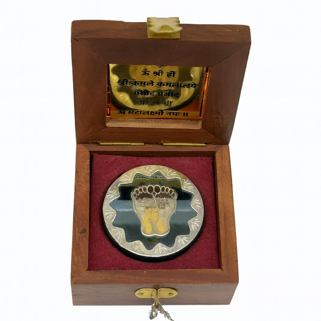 Laxmi Mantra Feet is a sterling silver medallion set inside a rosewood box, stamped with the goddess&