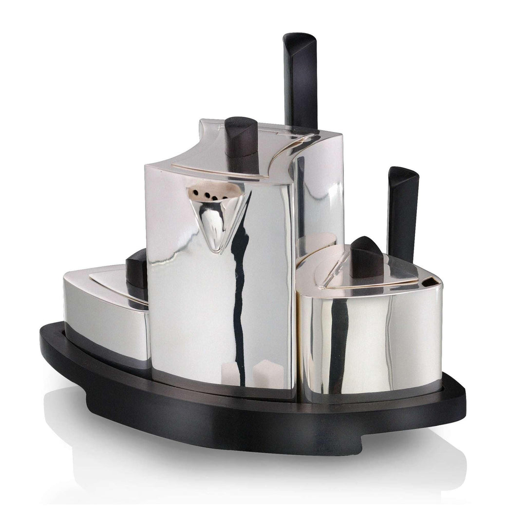Tea Set Navette is a silver teapot set with three attached vessels on a stepped, boat-shaped wood tray, plus a separate small triangular box