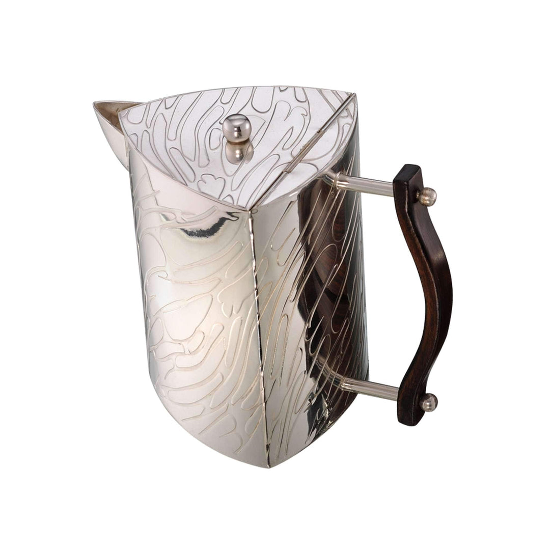 Tea Set Green Emblaze is a silver jug with a faceted, triangular silhouette wrapped in a swirling etched pattern and a dark wood handle - white background