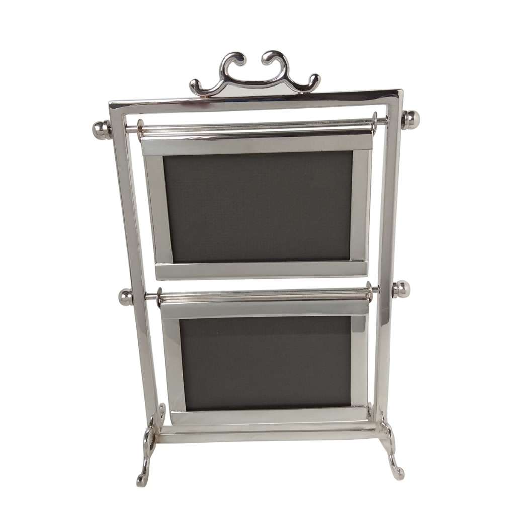 Photo Frame Duo is a freestanding silver frame that holds two photographs, one above the other, topped with a scrolled crest - white background