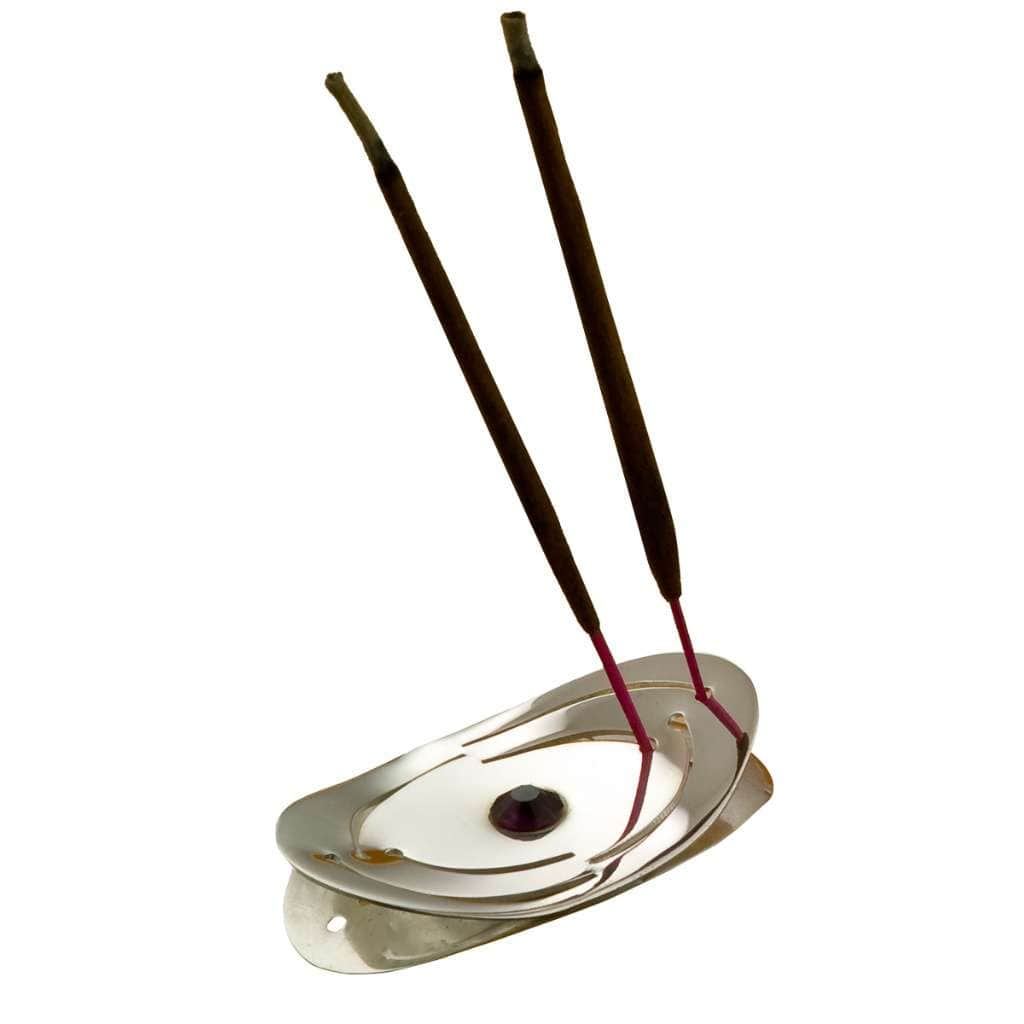 Incense Holder Tilak frames a single faceted purple stone at the centre of this oval silver incense holder with swirling cutouts - white background