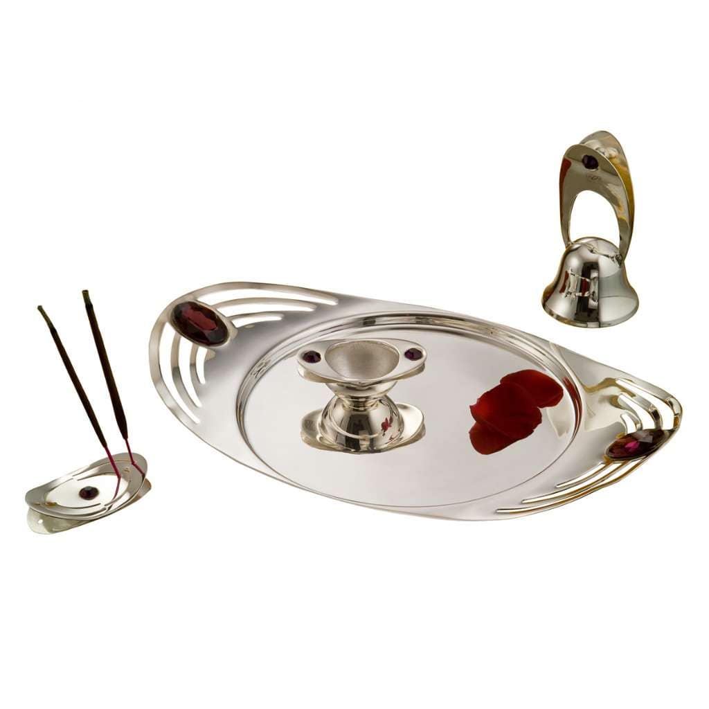Pooja Thali Tilak Set fits a faceted red gemstone accent to each piece on an oval fluted silver tray - white background
