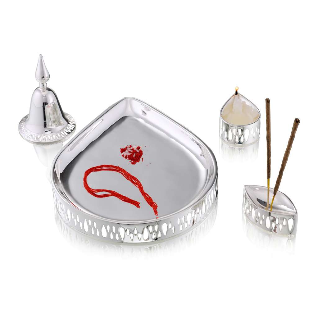 Pooja Thali Divine Set anchors a scalloped triangular silver tray, paired with a domed bell, a diya cup - white background