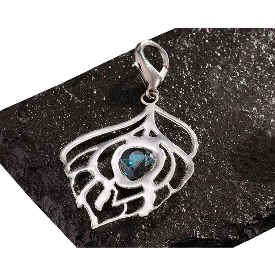Key Chain Mayuresh is a silver key chain tracing an open feather outline around a single faceted blue crystal at its centre - white background