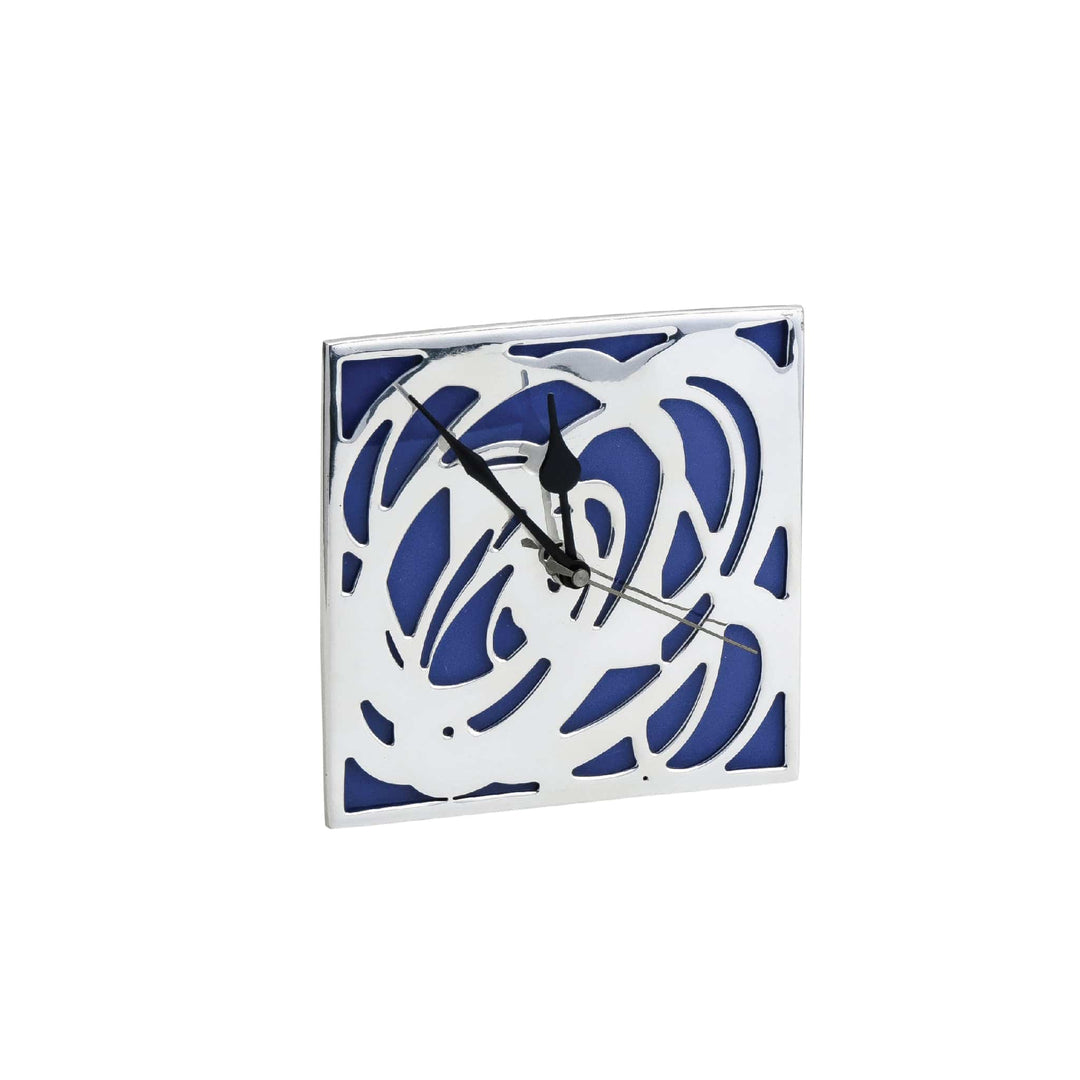 Table Clock Cosmos is a silver table clock with a mirror-polished square frame, cut into a flowing abstract pattern - white background