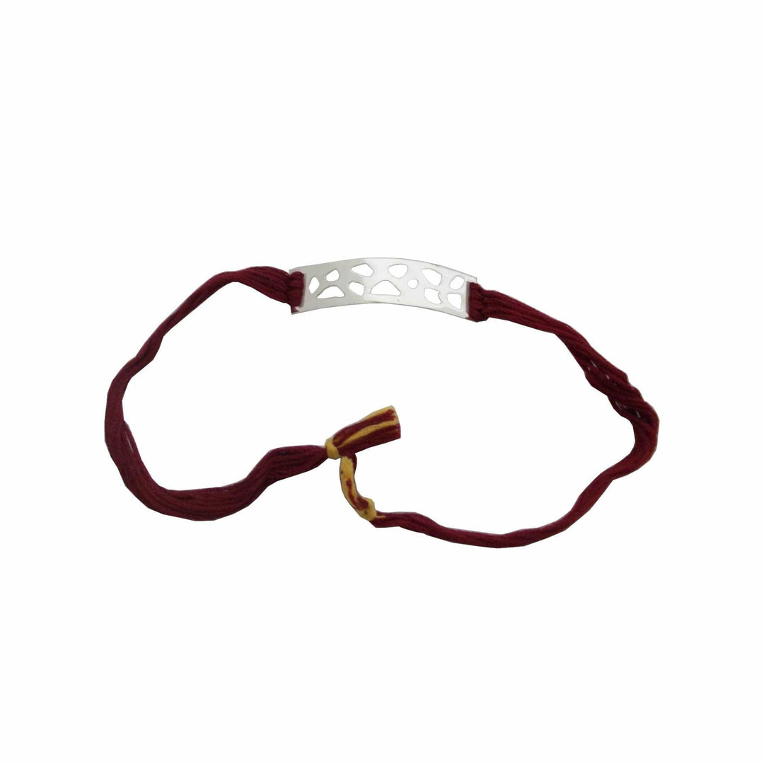 Rakhi Bandhan is a silver rakhi with a curved bar cut in an openwork pebble pattern on a maroon braided thread. - white background