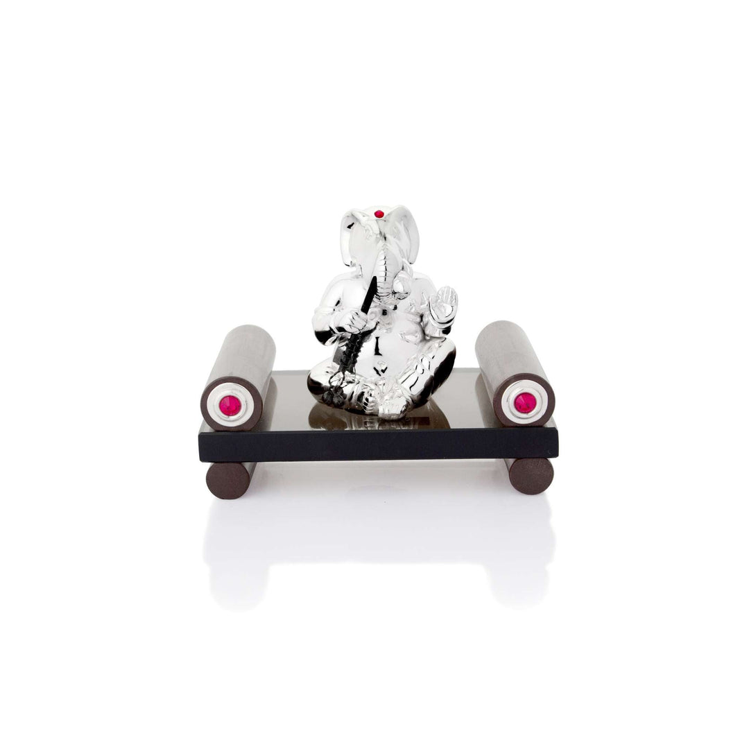 Ganesh Bansuri shows a sterling silver Ganesha idol seated cross-legged with a bansuri raised to his lips - white background