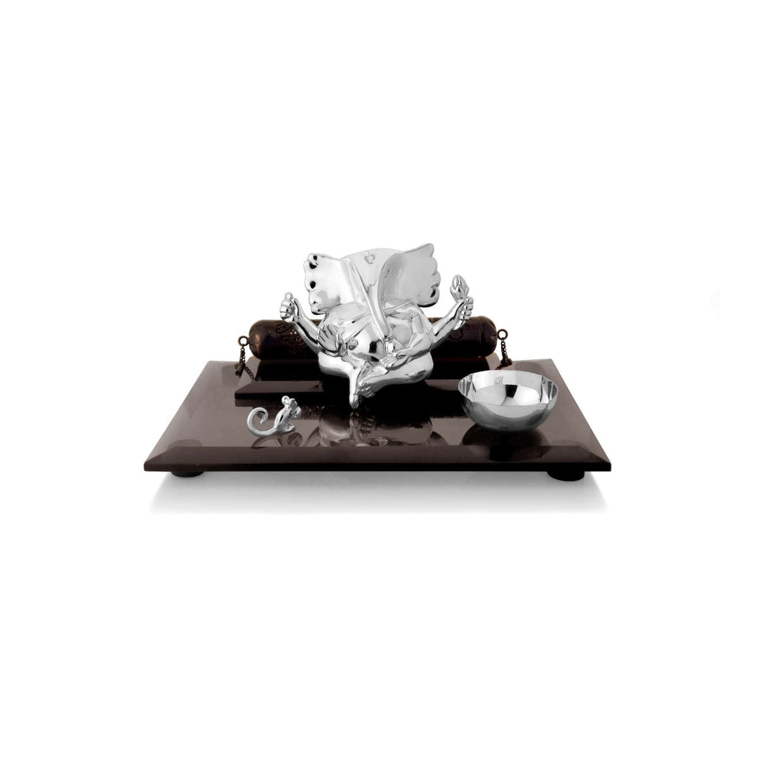 Ganesh Vighneshwara Wedding Invite sits a sterling silver Ganesha idol between two dark wood posts joined by fine chains - white background