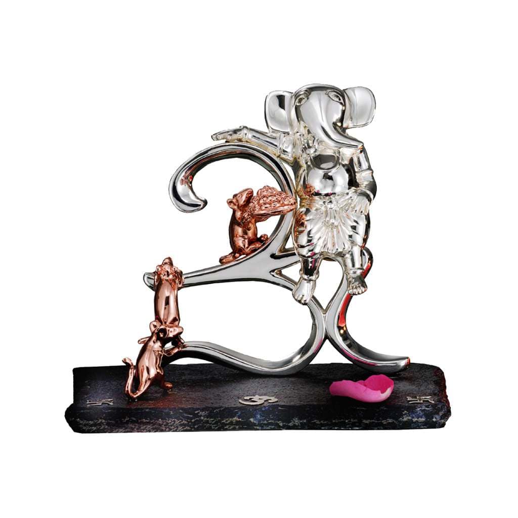 Ganesh Sewak stands a sterling silver Ganesha idol upright beside a large freestanding Om symbol rendered in the same polished silver - white background