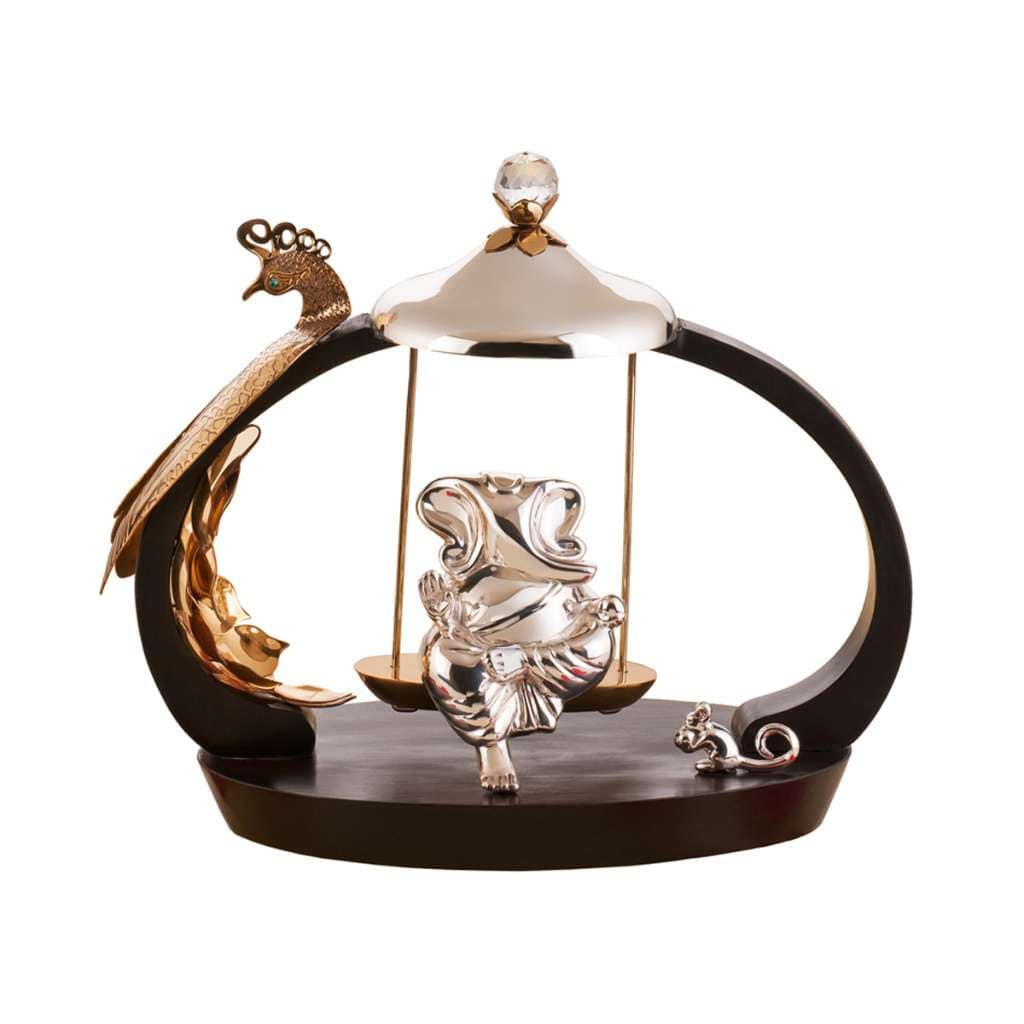 Ganesh Sawan seats a sterling silver Ganesha idol on a swing suspended inside an oval frame topped with a domed canopy and a crystal finial - white background