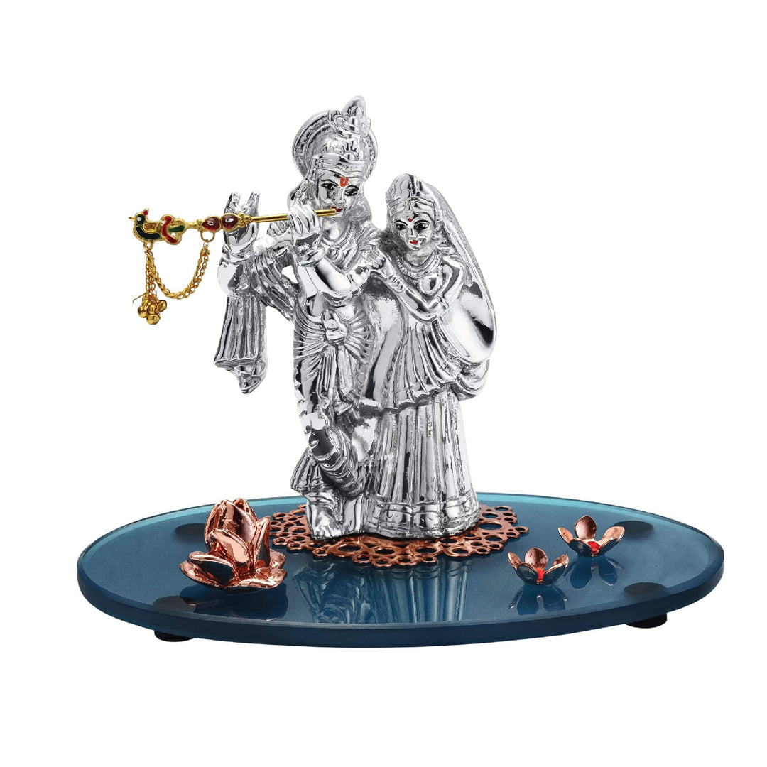 Radha Krishna Mayuresh is a sterling silver idol casting Krishna playing his flute with Radha standing close behind him - white background